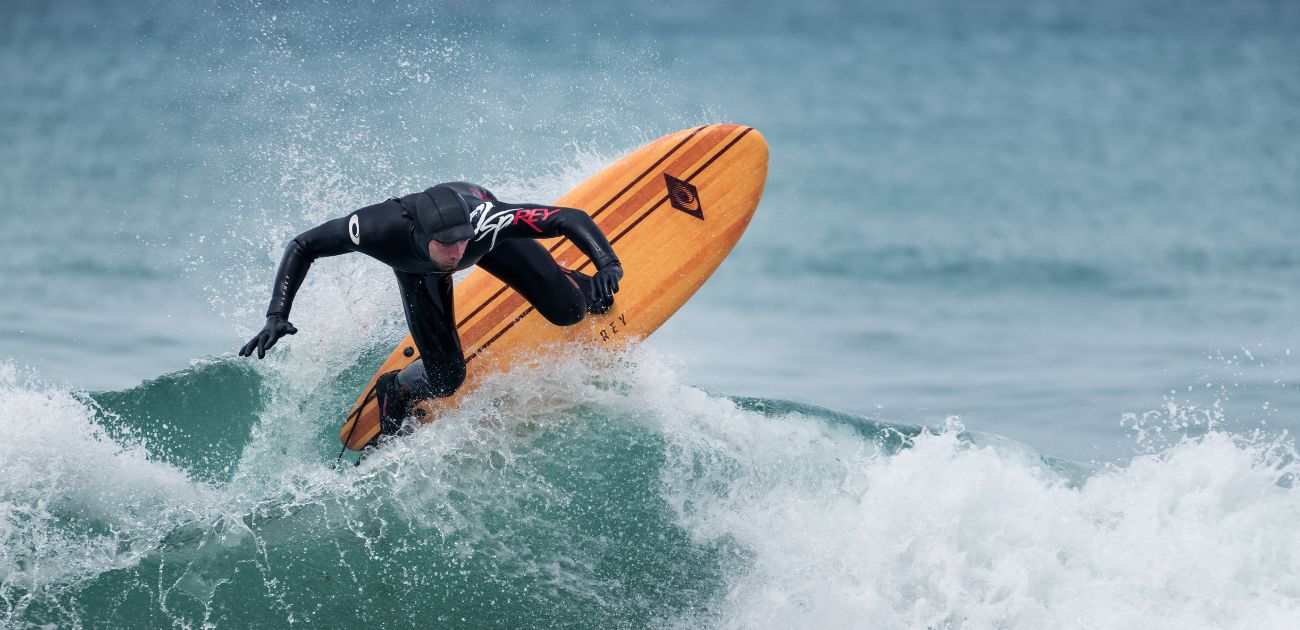 A man riding an Osprey surfboard on a wave