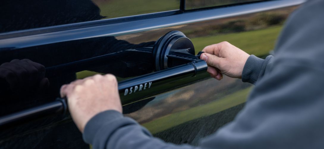 a picture of the Osprey suction wetsuit hanger being attached to the side of a car.