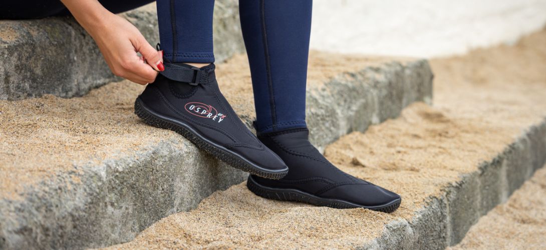 A close up photos of the Osprey wetsuit boots with some steps in the background